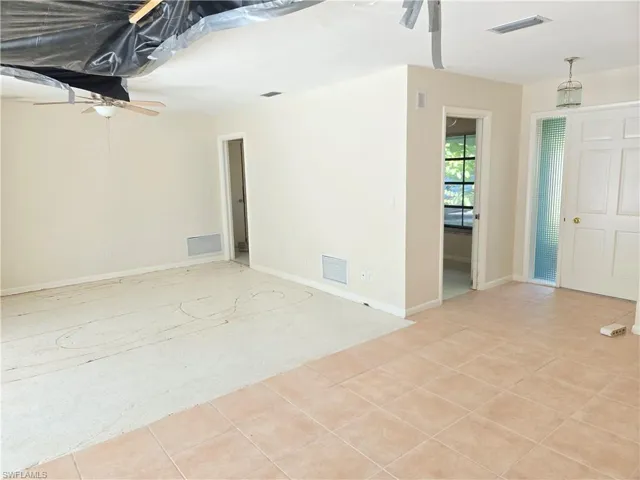 Featuring light tile patterned flooring and a ceiling fan
