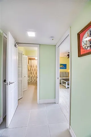 Hall featuring baseboards and light tile patterned flooring
