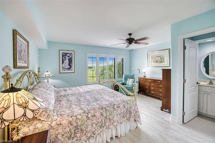 Bedroom featuring light wood-style flooring, a ceiling fan, and ensuite bath