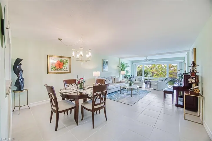 Dining area featuring a ceiling fan, light tile patterned flooring, and a chandelier