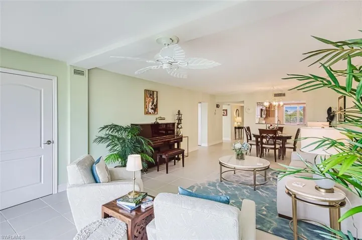 Tiled living room featuring baseboards and a ceiling fan