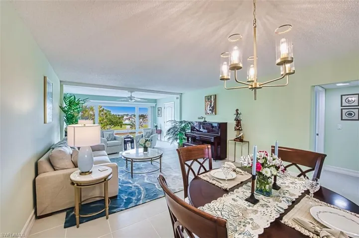 Tiled dining area featuring a textured ceiling, a chandelier, and a ceiling fan