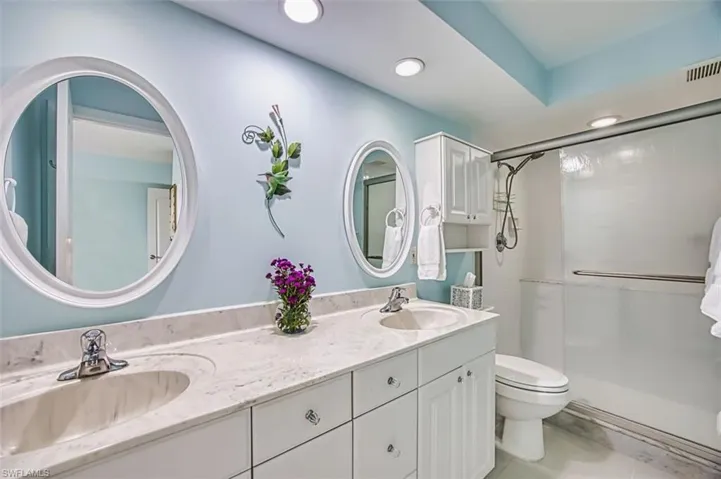 Bathroom with double vanity, a stall shower, and recessed lighting