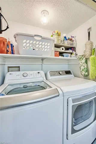 Washroom featuring washer and dryer and a textured ceiling