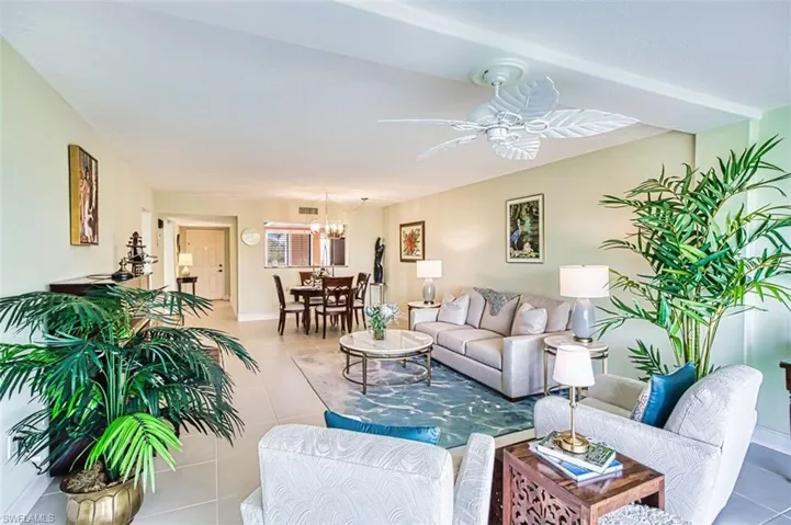 Tiled living area featuring a chandelier and a ceiling fan