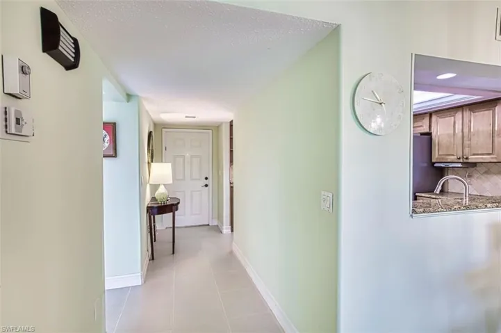 Hall featuring a textured ceiling and light tile patterned flooring