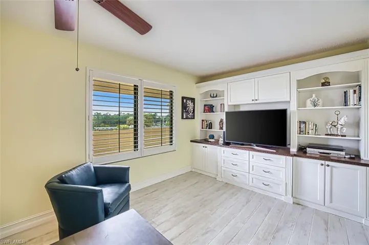 Living area with ceiling fan and light wood-style flooring