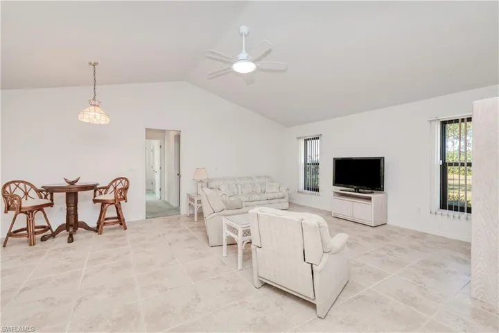 Living room with ceiling fan and lofted ceiling