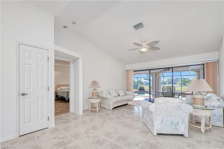 Living room featuring vaulted ceiling and ceiling fan