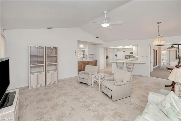 Living room featuring ceiling fan and lofted ceiling