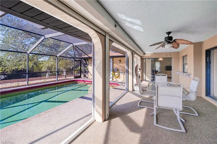 View of patio / terrace featuring ceiling fan and a lanai
