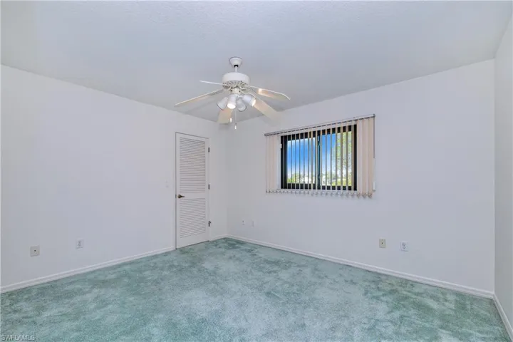 Empty room featuring light carpet and ceiling fan