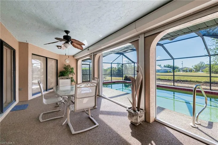Sunroom / solarium with ceiling fan and a swimming pool