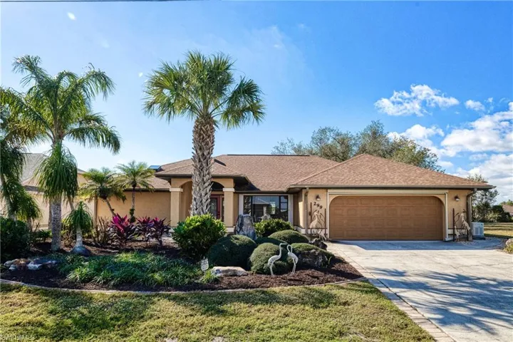 Single story home featuring central AC unit and a garage