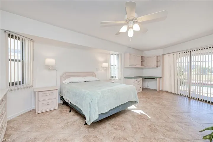 Bedroom featuring multiple windows, access to exterior, and ceiling fan