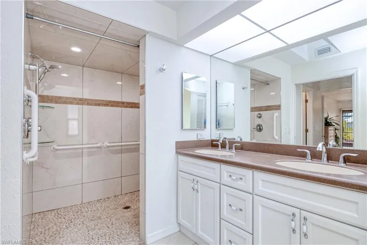 Bathroom with vanity and tiled shower