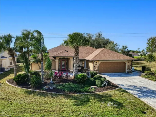 View of front facade featuring french doors, central AC, a garage, and a front lawn