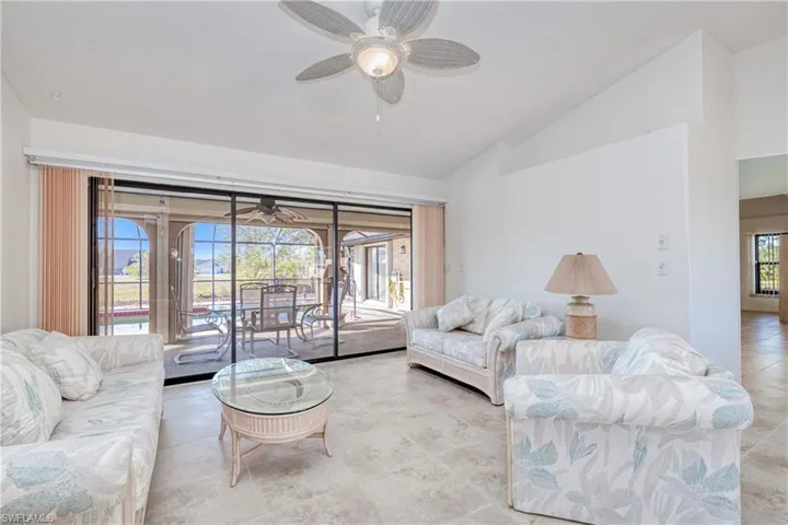 Living room featuring ceiling fan and vaulted ceiling