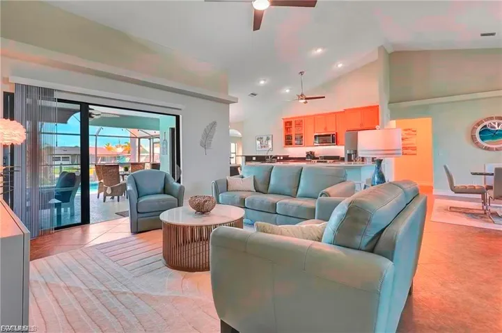 Living area with ceiling fan, recessed lighting, light tile patterned floors, and vaulted ceiling