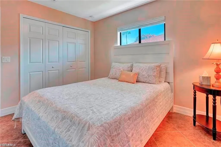 Tiled bedroom featuring baseboards and a closet