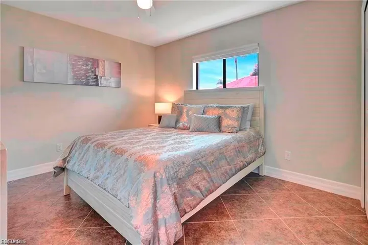 Bedroom with tile patterned flooring, a closet, and a ceiling fan