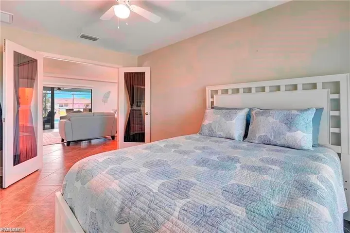 Tiled bedroom featuring ceiling fan