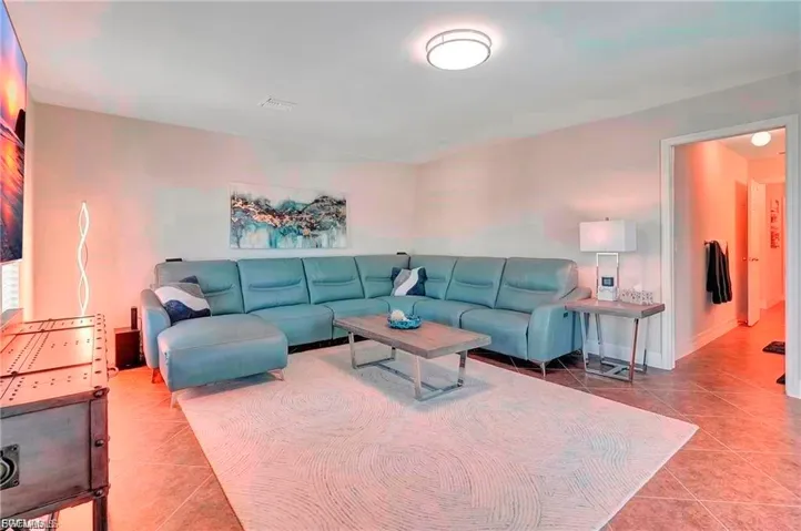 Tiled living area featuring baseboards