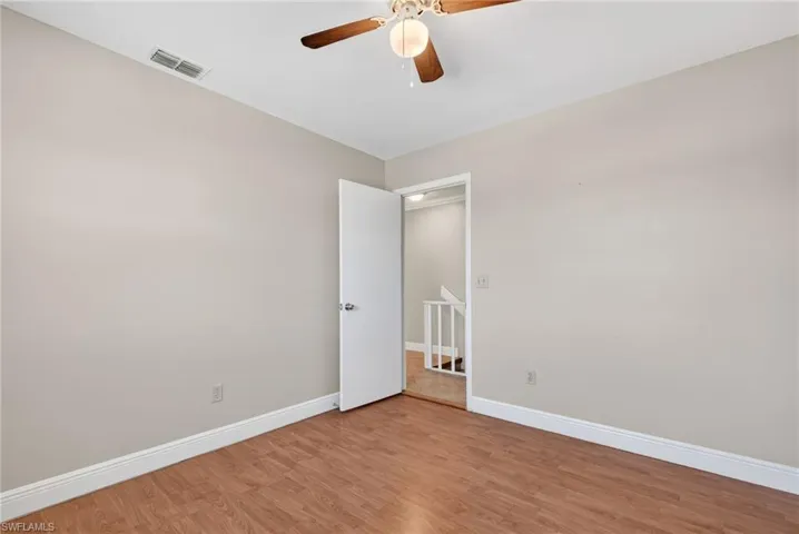 Empty room with wood finished floors and ceiling fan