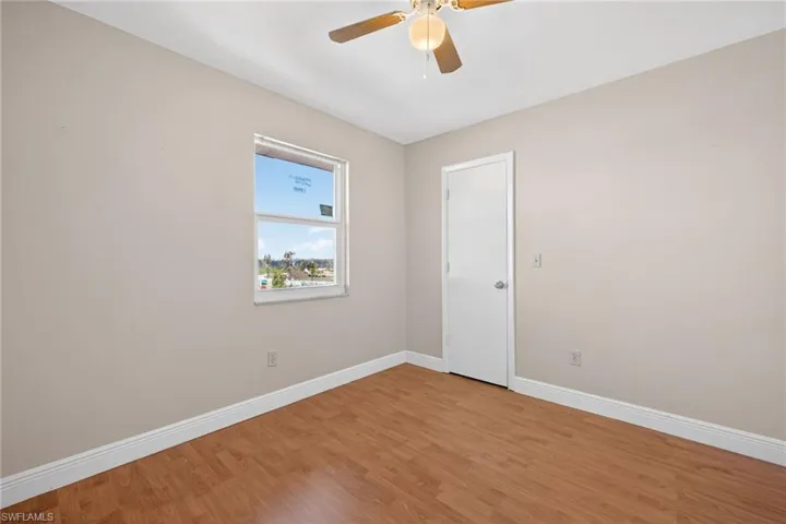 Spare room with wood finished floors and ceiling fan