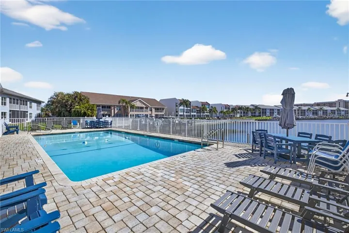 Community pool with a patio area and a residential view