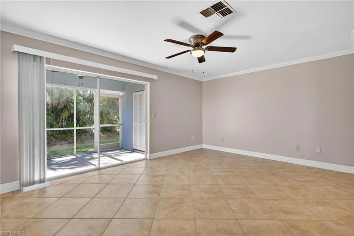 Spare room featuring crown molding, ceiling fan, and light tile patterned flooring