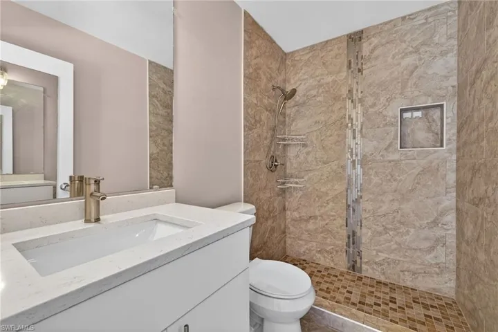Full bath with a shower stall and vanity