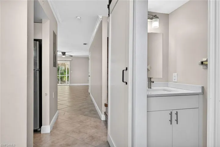 Hallway featuring ornamental molding and light tile patterned floors