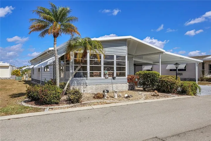 View of side of property featuring a sunroom and an attached carport