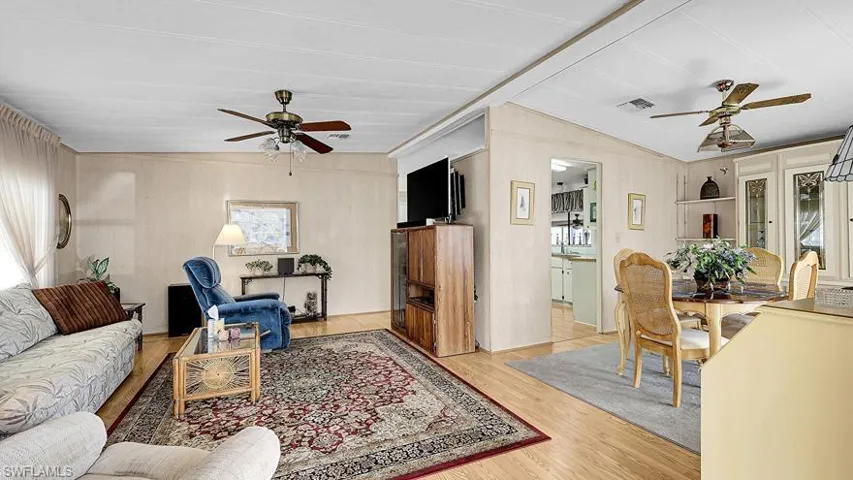 Living room featuring a ceiling fan, light wood-type flooring, and healthy amount of natural light