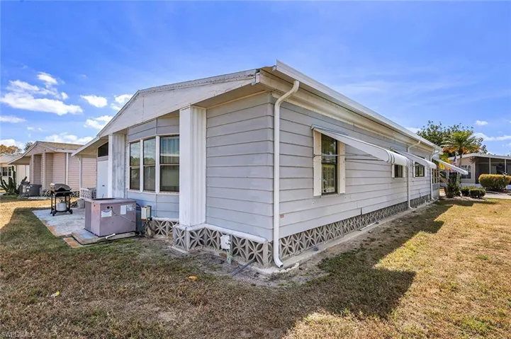 View of side of property with a yard and a patio area