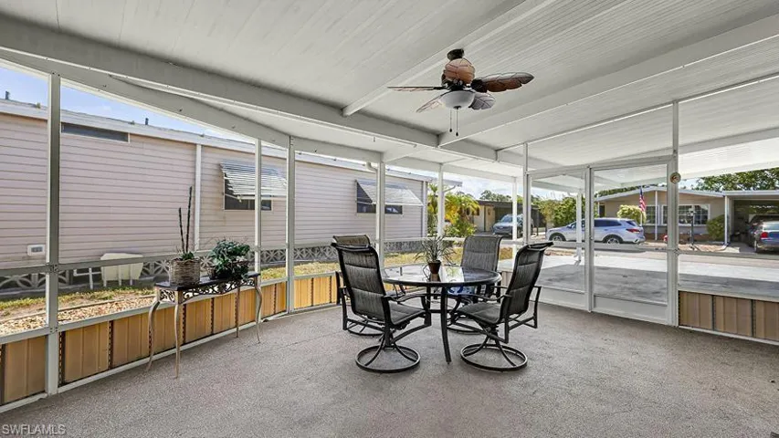 Sunroom / solarium featuring ceiling fan, healthy amount of natural light, outdoor dining space, and beam ceiling