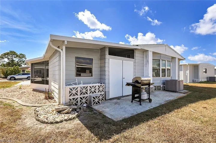 Back of property featuring a sunroom and a lawn
