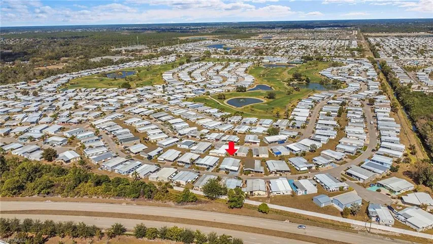Aerial view of residential area featuring a nearby body of water and a golf course