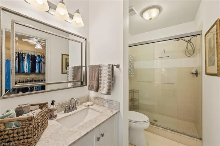 Bathroom with vanity, tile patterned floors, toilet, and walk in shower