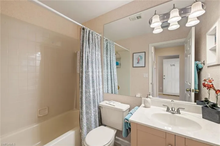 Full bathroom with vanity, toilet, and shower / bath combo with shower curtain