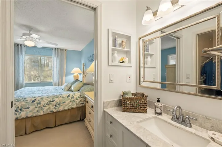 Carpeted bedroom with ceiling fan, sink, and a textured ceiling