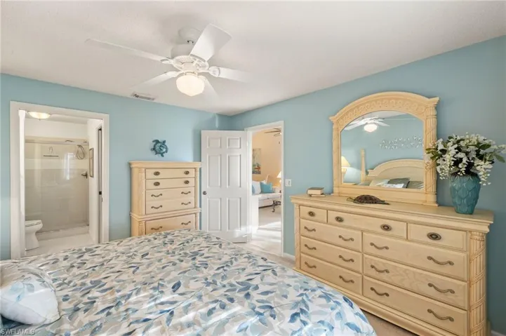 Bedroom featuring ensuite bath and ceiling fan