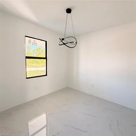Empty room featuring light marble finish floors and baseboards