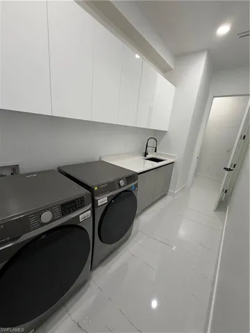 modern, spacious laundry room with ample storage and natural light
