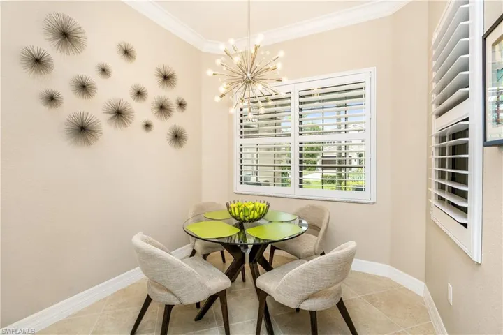Dining space featuring crown molding, a chandelier, and light tile patterned flooring