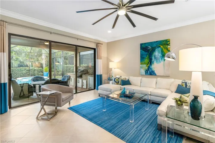 Living area featuring ornamental molding, a ceiling fan, and tile patterned floors
