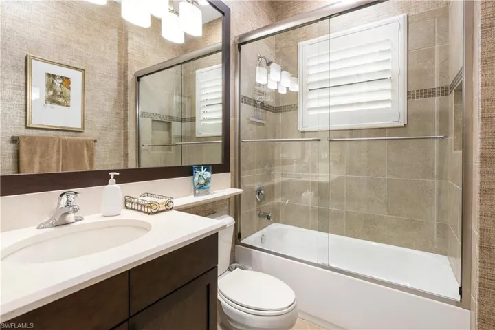 Full bath featuring vanity and bath / shower combo with glass door