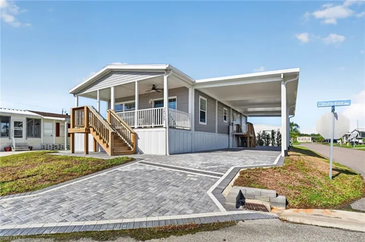 Exterior featuring horizontal siding and a covered front porch with natural wood stairs