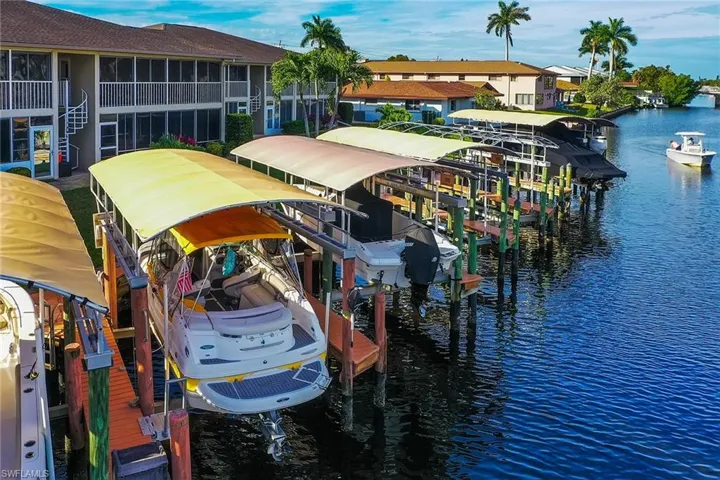 Dock area with boat lift, a water view, and a residential view